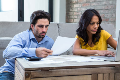 A couple reviews their mortgage paperwork to remove PMI