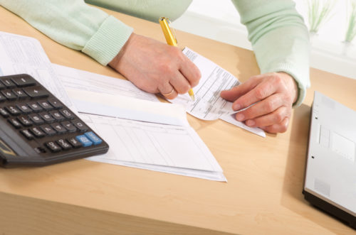 Old woman depositing checks into her account.