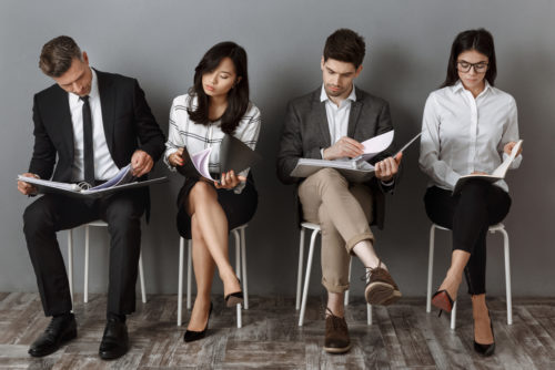 Concentrated multicultural business people with folders and notebooks waiting for job interview