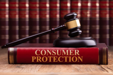 A gavel representing the law on top of a consumer protection textbook.