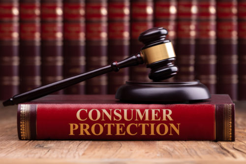 A gavel representing the law on top of a consumer protection textbook.