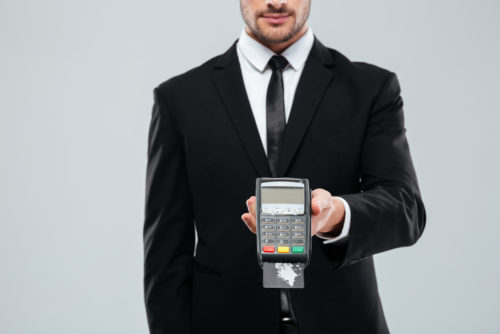 businessman holding a credit card terminal