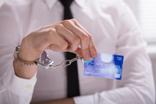 Man handcuffed to a credit card he is holding