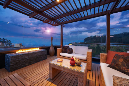 Modern terrace lounge overlooking an ocean at sunset