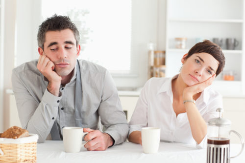 Bored couple drinking coffee in a kitchen