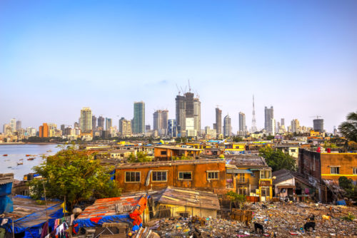Skyline of a modern city in the background with a slum in a foreground