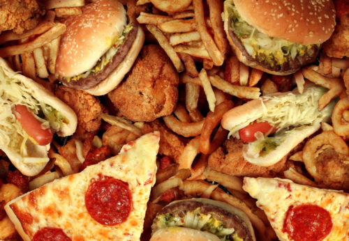 A mass of hamburgers, fries, pizza slices, hot dogs, and fried chicken.