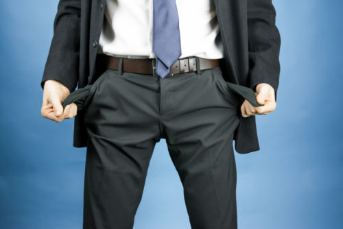 Man in a suit with outturned, empty pockets.