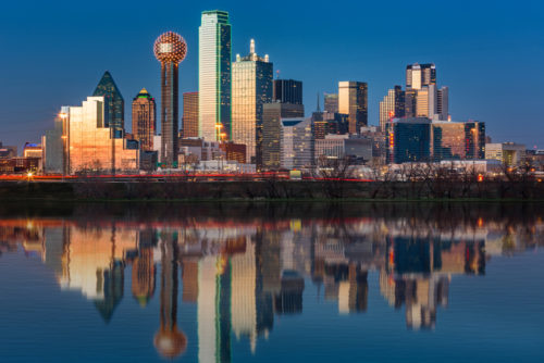 The Dallas skyline just after sunset, with the skyline reflected in the Trinity River.