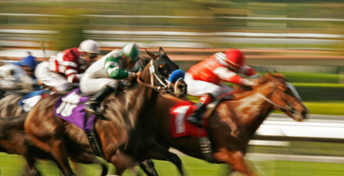 Jockeys and horses vie for position in a blur of motion and speed.