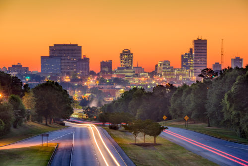 The Columbia, South Carolina skyline at dusk, with long-exposure car light trails.