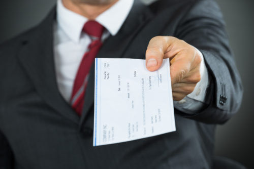 businessman handing over payroll check,