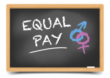 A graphic of a chalkboard with the words equal pay and gender symbols written on it.