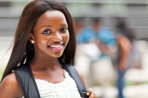 Smiling high school-age student with backpack on