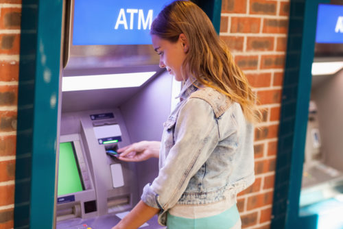 A student accessing her bank account through an ATM.