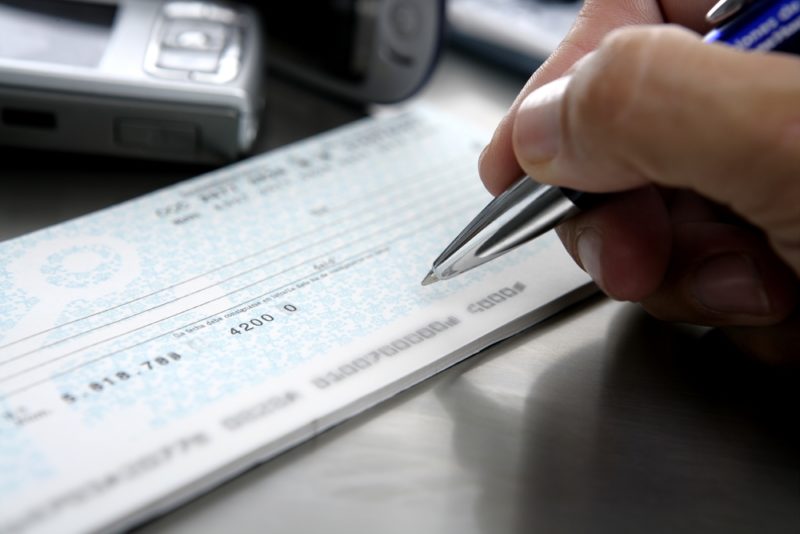 A man writing a check to cash.