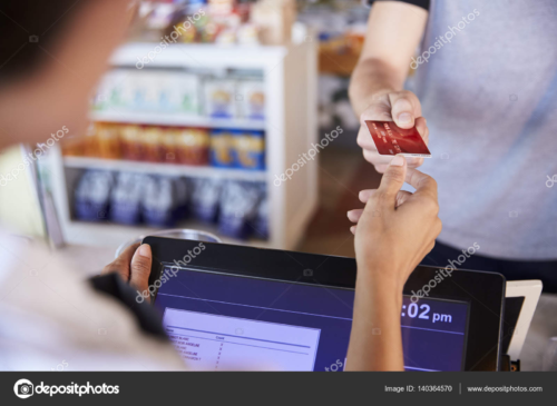 A grocery store cashier accepts a debit card.