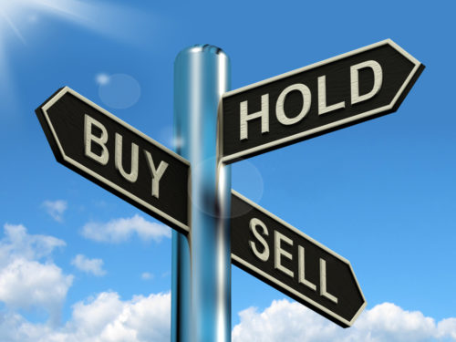 A sign pointing three ways, with each arrow labeled three options of trading stocks, "buy," "hold," and "sell."