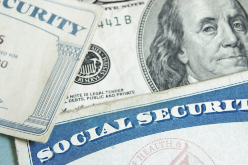 Social Security cards laying on top of some money.