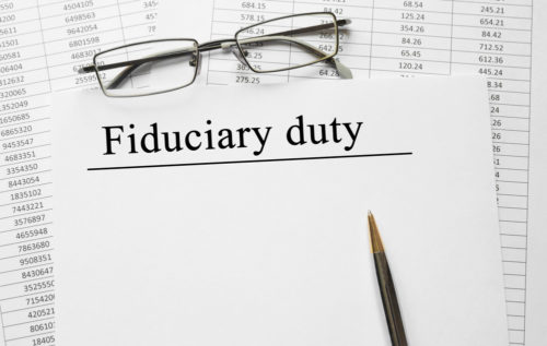 Eyeglasses and a pen sit on top of a document labeled "fiduciary duty."