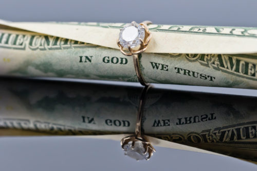 A dollar bill rolled up into a wedding ring .