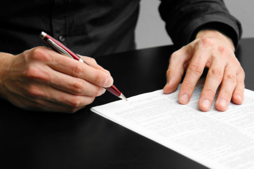 A man sitting down to a table to write a letter.