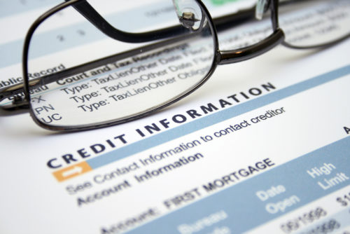 Eyeglasses sit on top of a credit information sheet.