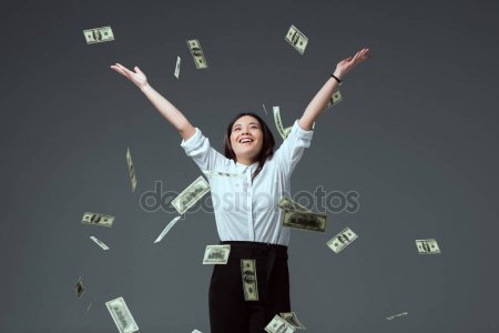 Young woman joyfully throwing money into the air.