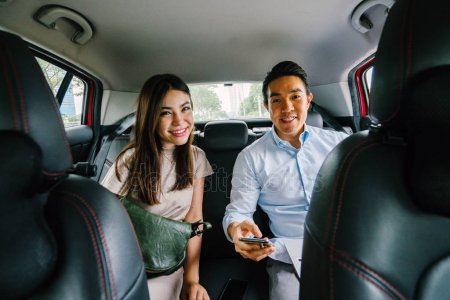 A young woman and a young man sitting in the backseat of an Uber vehicle.