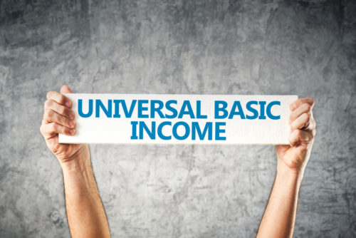A person's arms holding up a banner that says "universal basic income."