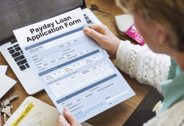 A woman holding a payday loan application form.