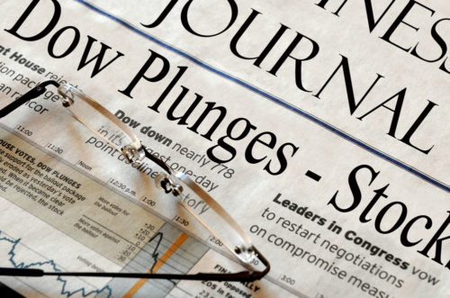 A newspaper reporting on the financial crisis that reads "Dow Plunges."