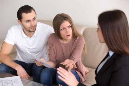 An unhappy couple argues with a mortgage broker about their predatory mortgage loan.