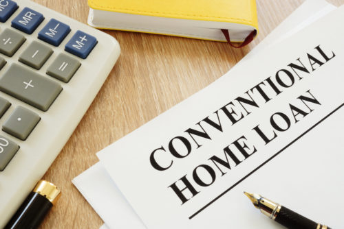 A document labeled "conventional home loan" sits on a desk alongside a calculator and a planning notebook.
