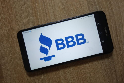 A smartphone has a screen that shows BBB, the Better Business Bureau logo.