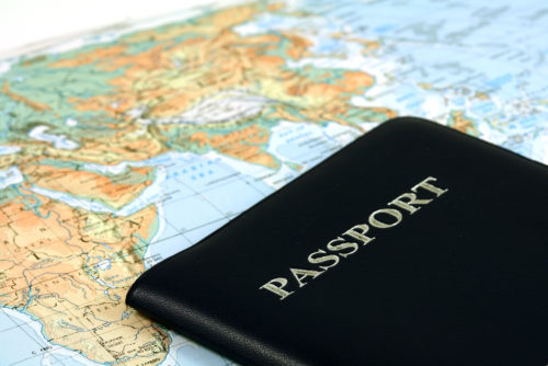 The passport of a traveler sits on top of a map.