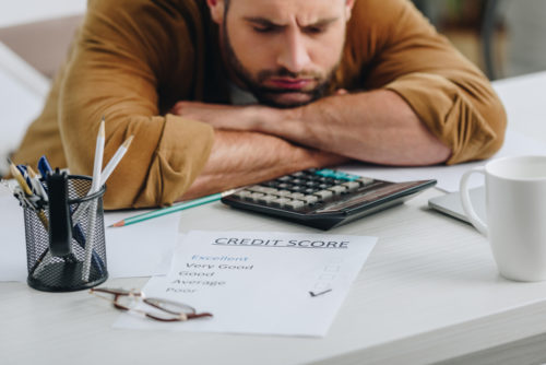 A sad student looks over a credit score document.