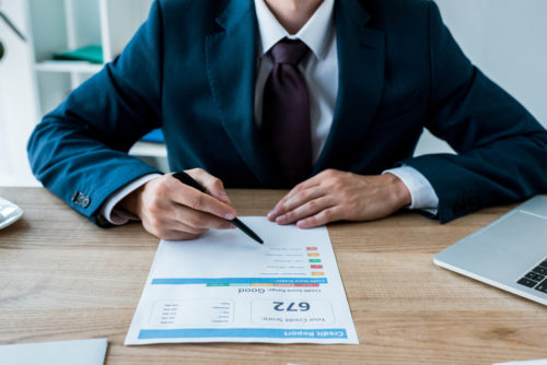 A lender at a desk, looking at a credit report and fixing a billing error as part of the Fair Credit Billing Act.