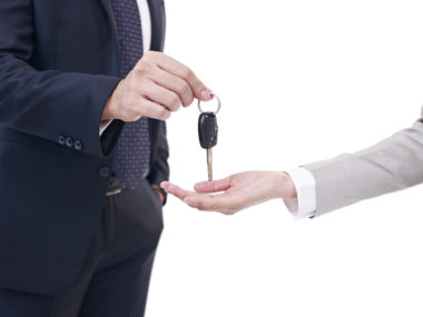 A man returning the keys to his car to a saleswoman.