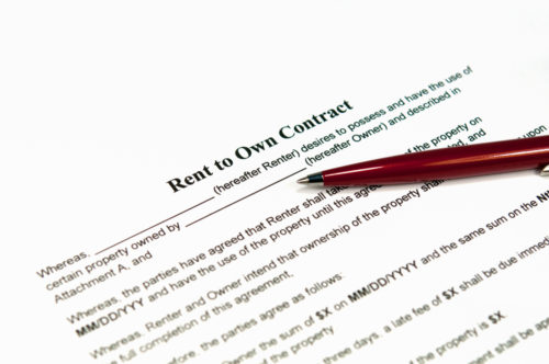 A pen sits on top of a rent-to-own contract.