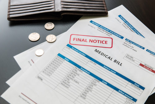An open wallet spills coins over a medical bill that is rubber stamped "final notice."