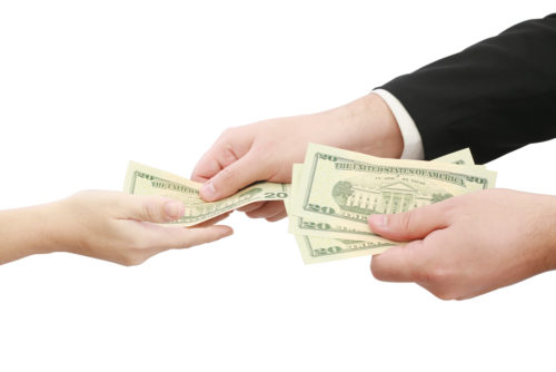 A woman employee receiving money from a businessman.
