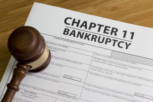 A gavel sits on to of a document titled "chapter 11 bankruptcy."
