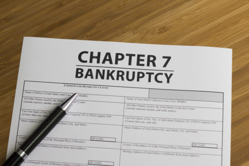 A pen sits on top of a document labeled "chapter 7 bankruptcy."