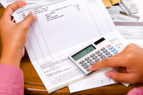 A woman calculating her credit score after filing for bankruptcy.