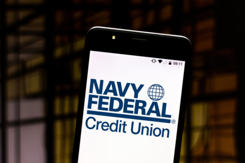 A smartphone with a screen displaying the Navy Federal Credit Union website.