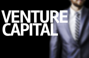 An investor stands behind the words "venture capital."