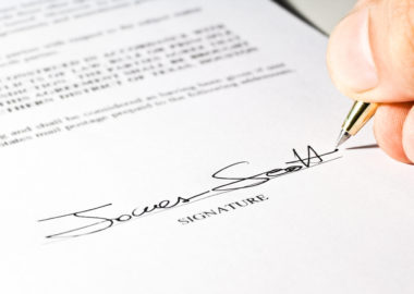 A woman signing the bottom of a special warranty deed.