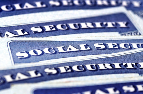 Several Social Security cards laying on top of each other.