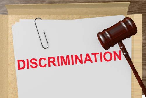 A gavel sits on top of a document labeled "discrimination."